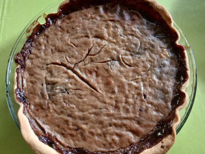 Bosvruchtentaart in een glazen vorm: ambachtelijke confituur onder een goudbruine laag pudding