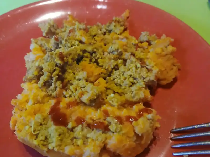 Portie hachis parmentier met wortelpuree en gehakt op een rood bord