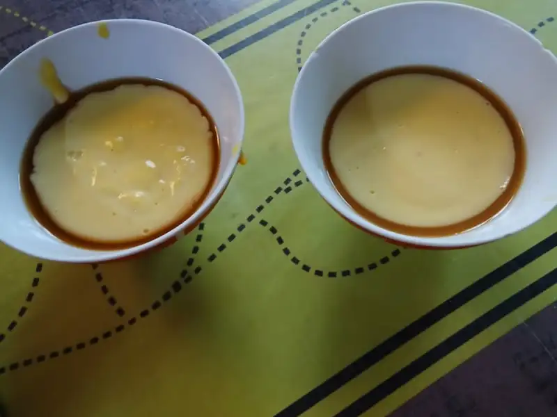 Twee gestorte karamelpuddings in witte kommetjes