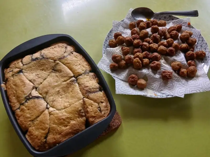 Goudbruine kersencake in een vierkante vorm, naast een bord kleine balletjes